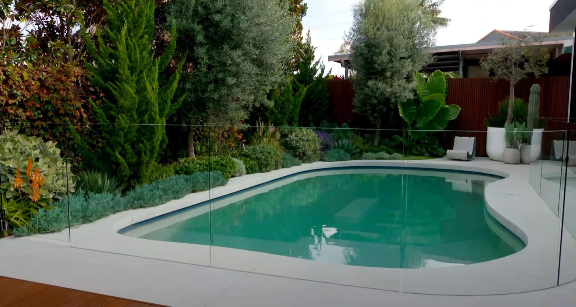 Outdoor Living Space Design - Pool Area with Seating and Landscape Features Modern backyard with swimming pool, outdoor seating area, and professional landscape design for entertaining